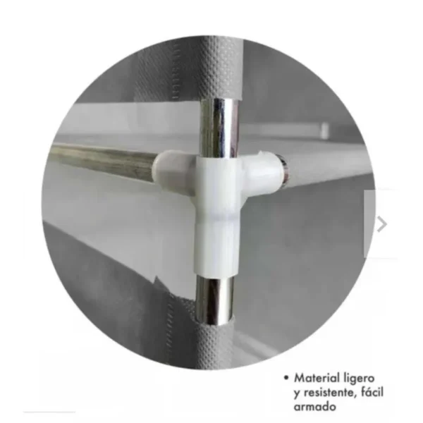Conector plástico blanco uniendo tubos metálicos en un armario.